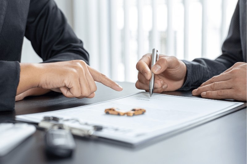 Asian man signing on an insurance claim form