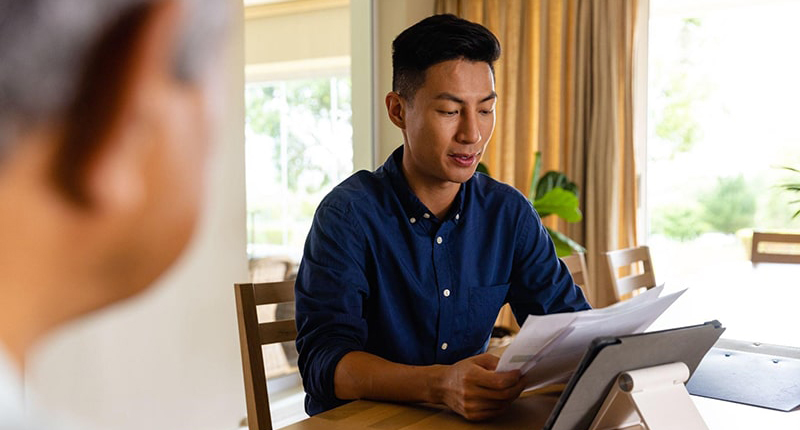 man reviewing his early critical illness insurance policy 800x534